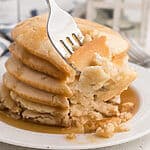 air fried pancakes stacked on a plate, topped with syrup, and a bite shot of the pancakes on a fork.