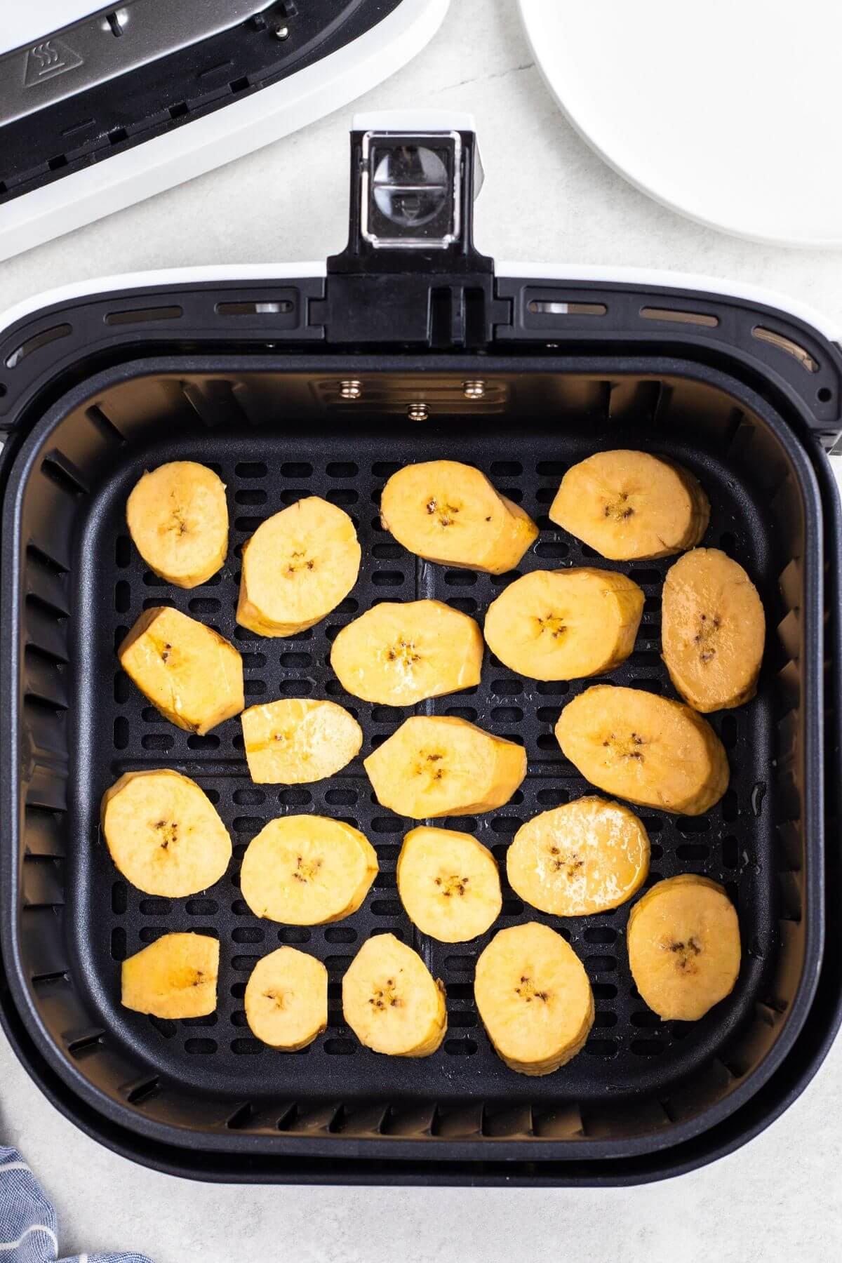 Plantain slices in the air fryer before being cooked. 