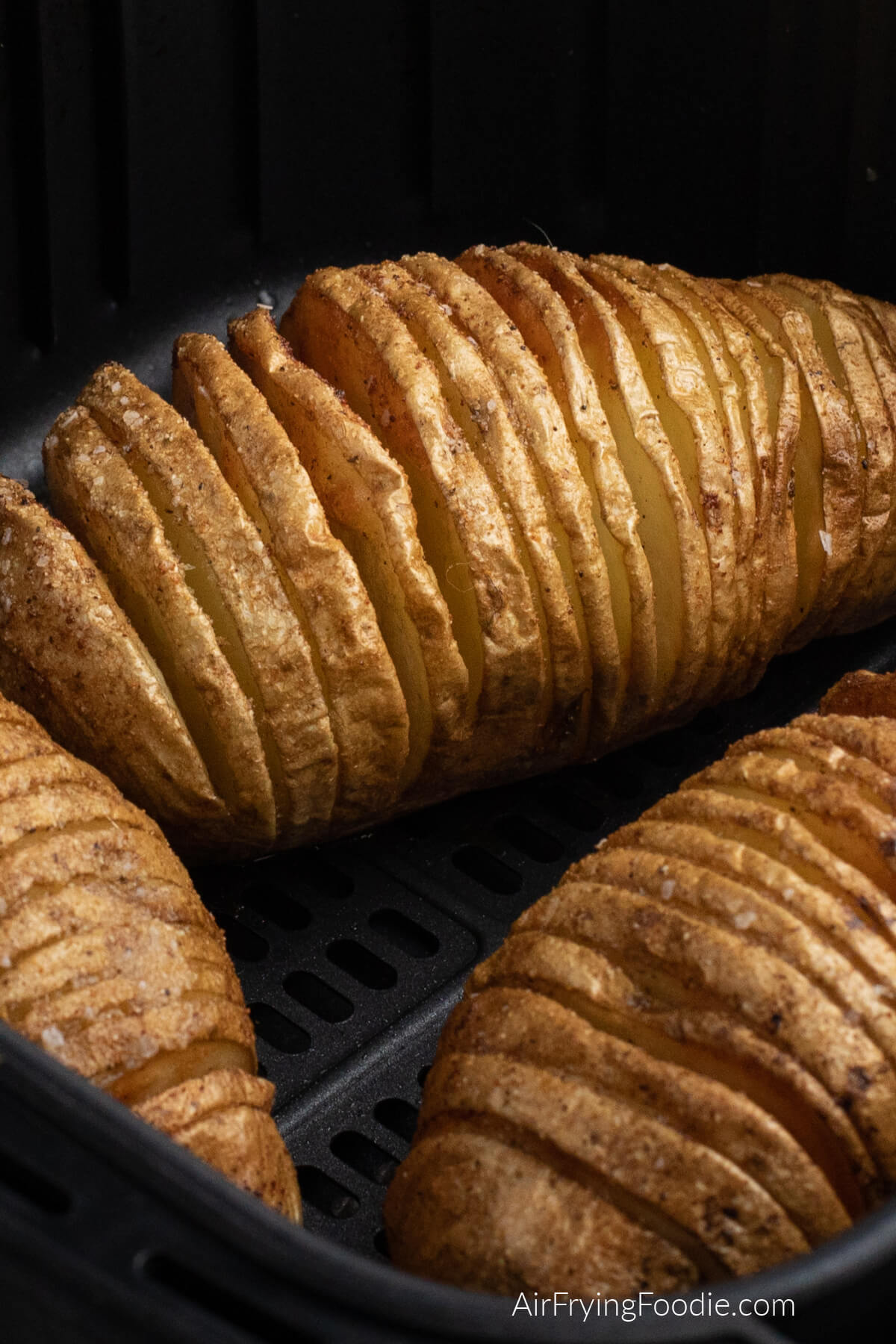 Hasselback potatoes in air fryer basket full cooked and ready to serve.