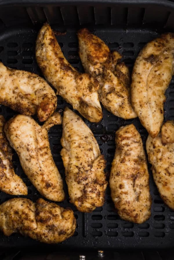 Reheated chicken tenders in the air fryer basket.