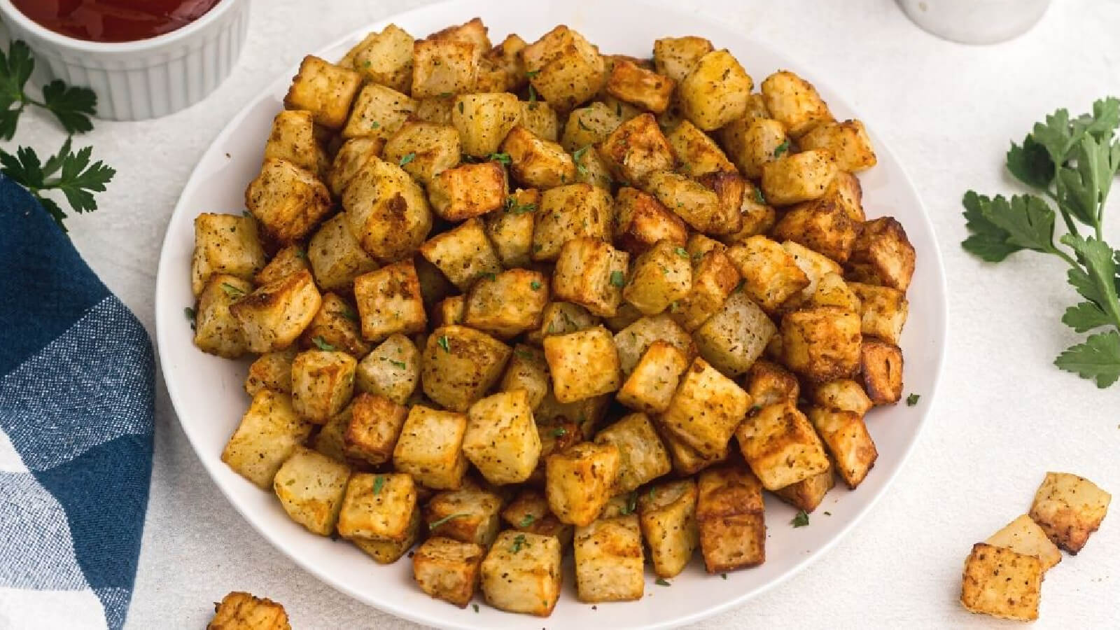 Air fryer breakfast potatoes on a white plate. 