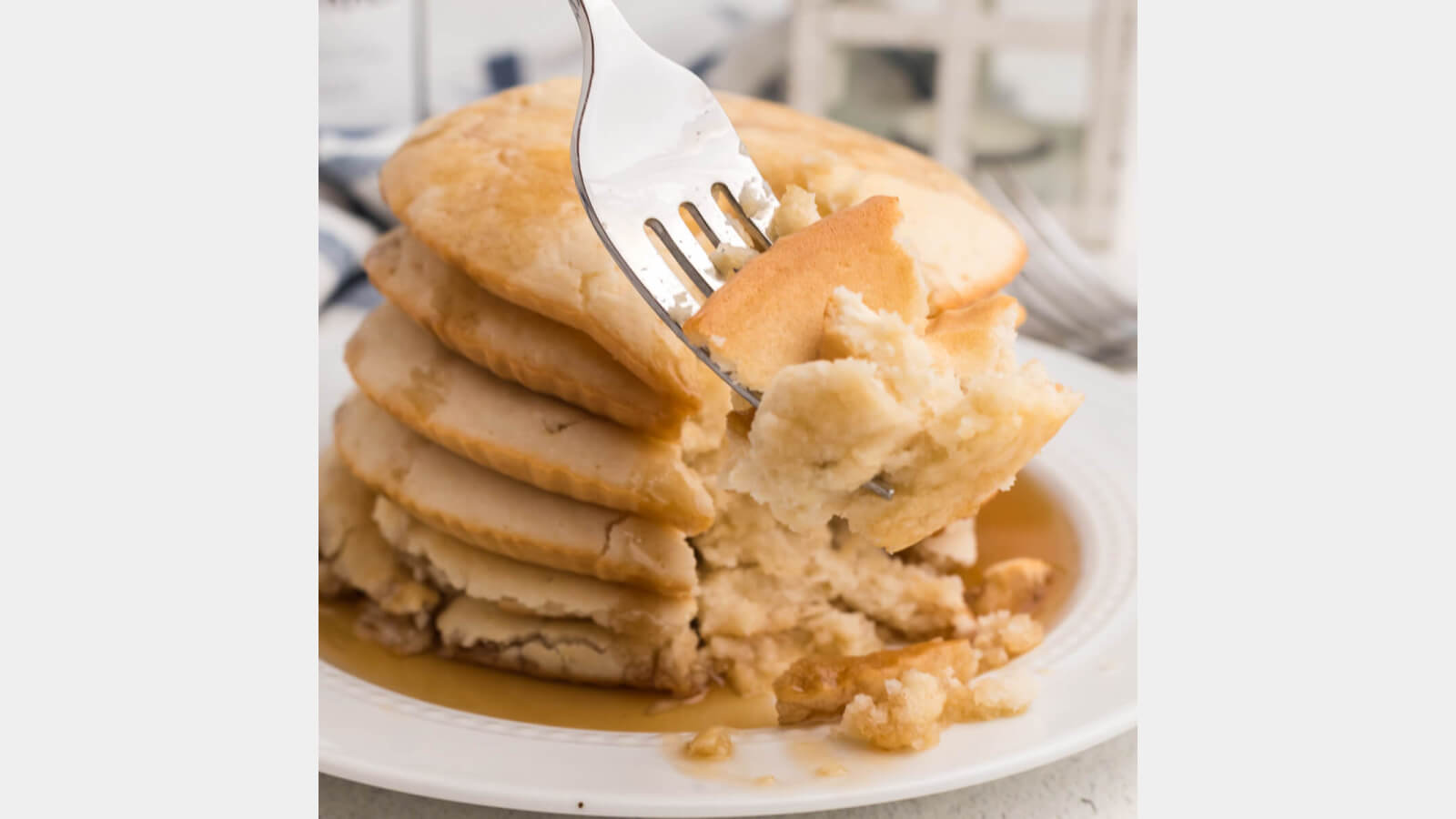 air fryer pancakes on a white plate with a bite on a fork. 