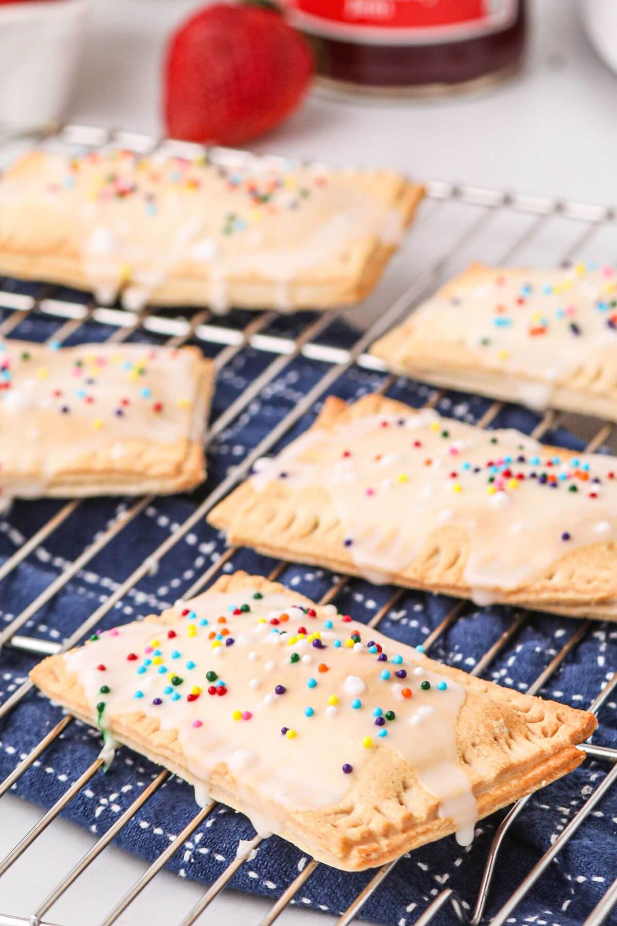 Close up photo of homemade pop tart with drizzle of frosting glaze and sprinkles. 