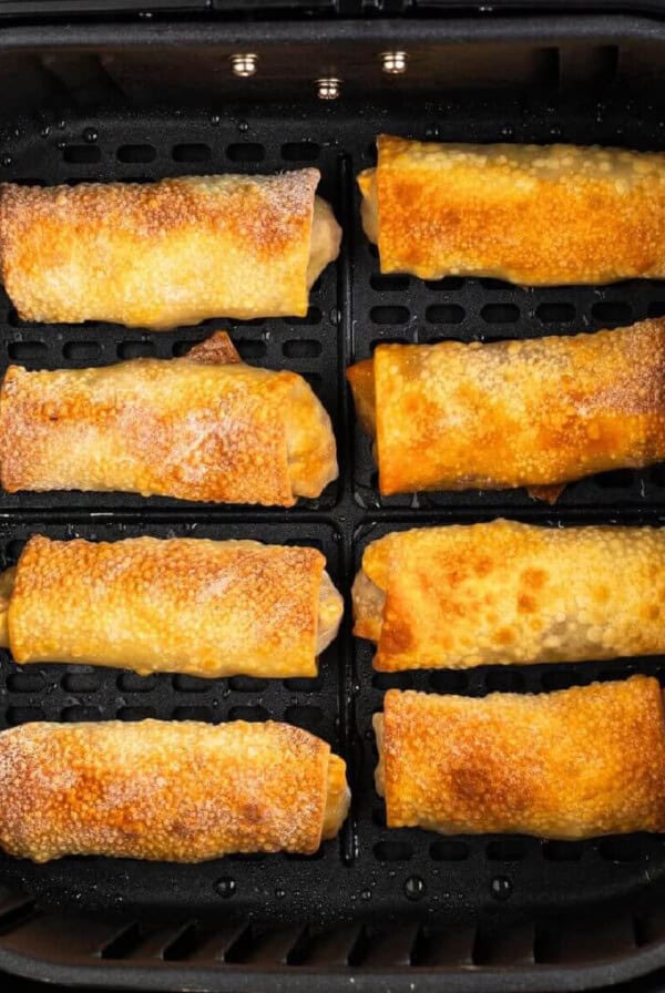 Egg rolls in the air fryer basket, fully cooked, and ready to serve.