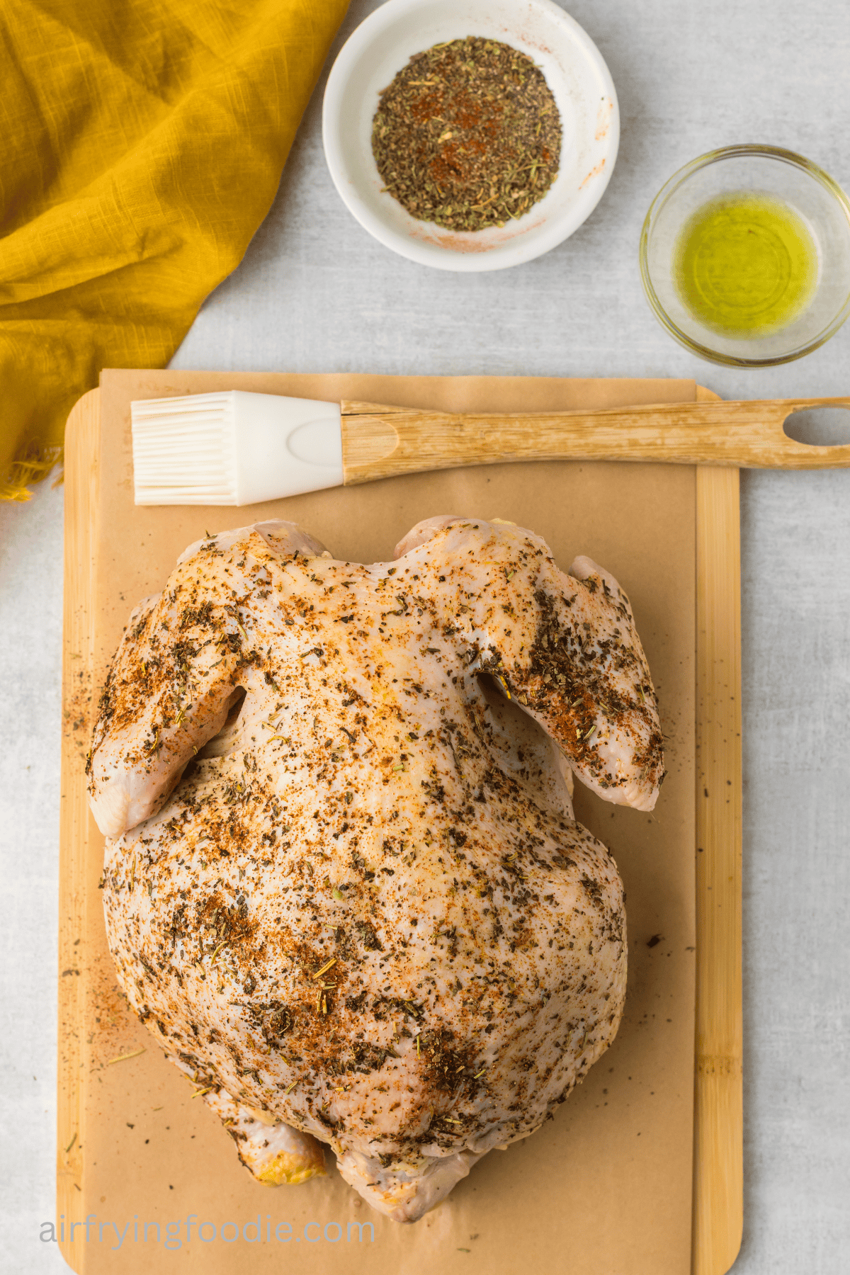 whole chicken brushed with olive oil and rubbed with seasonings.