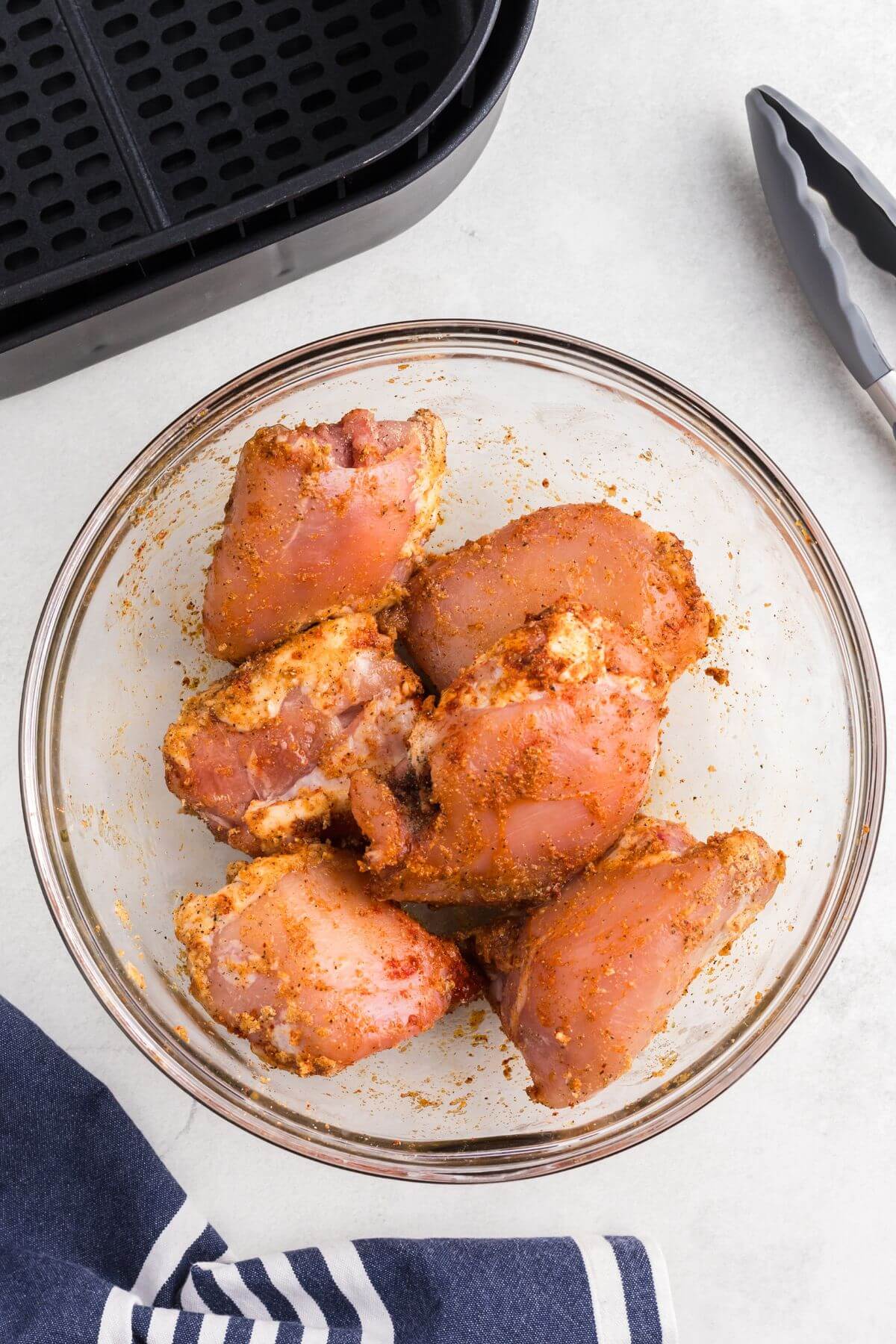 seasoned chicken thighs in a clear glass bowl