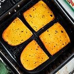 Golden crispy buttered garlic bread in the air fryer basket after being cooked.