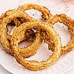 Close up on onion rings on a white plate.