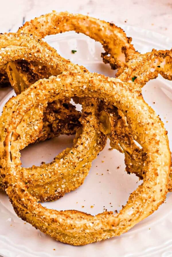 Close up on onion rings on a white plate.