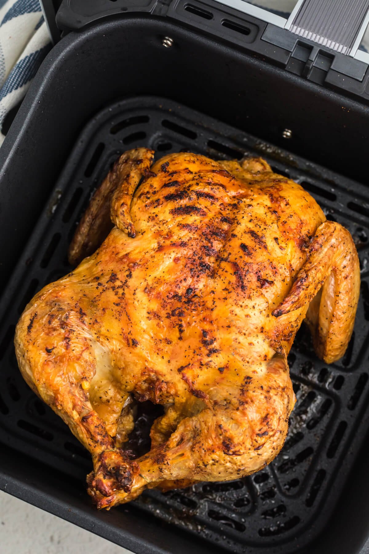 Reheated Rotisserie chicken in the basket of the air fryer. 
