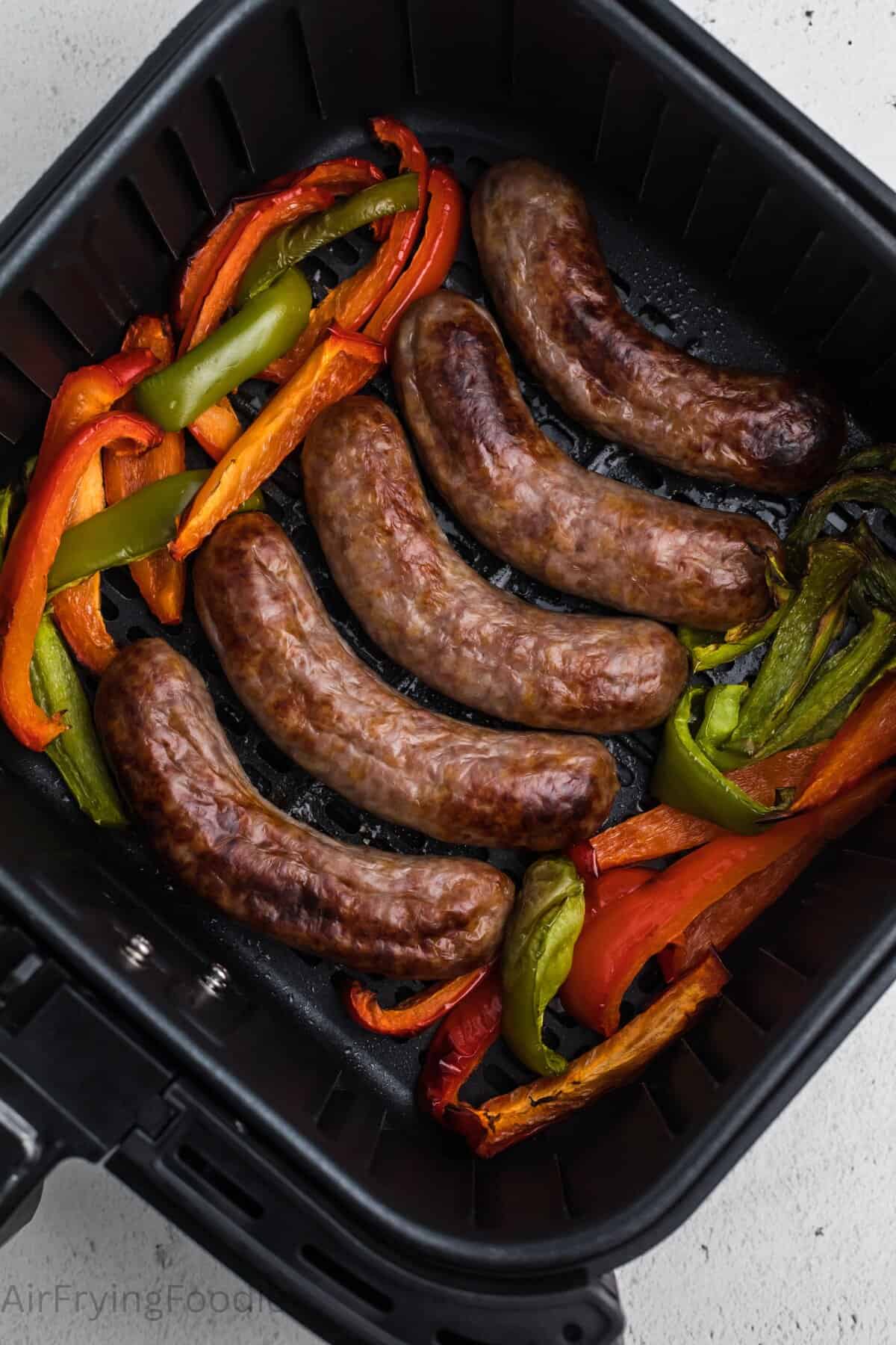 Air fryer bratwurst cooked in an air fryer basket.