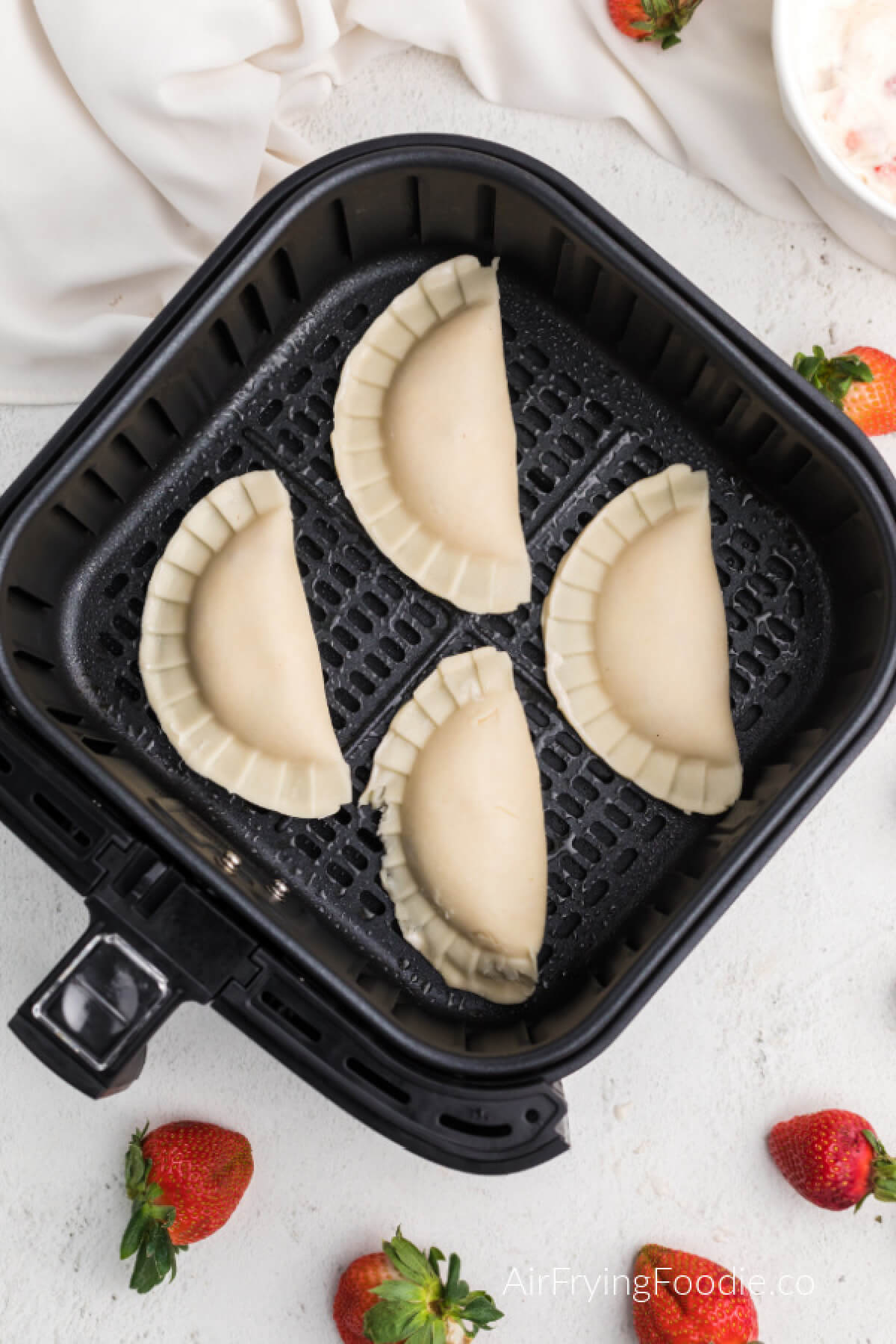 Hand pies in air fryer basket, ready to cook. 