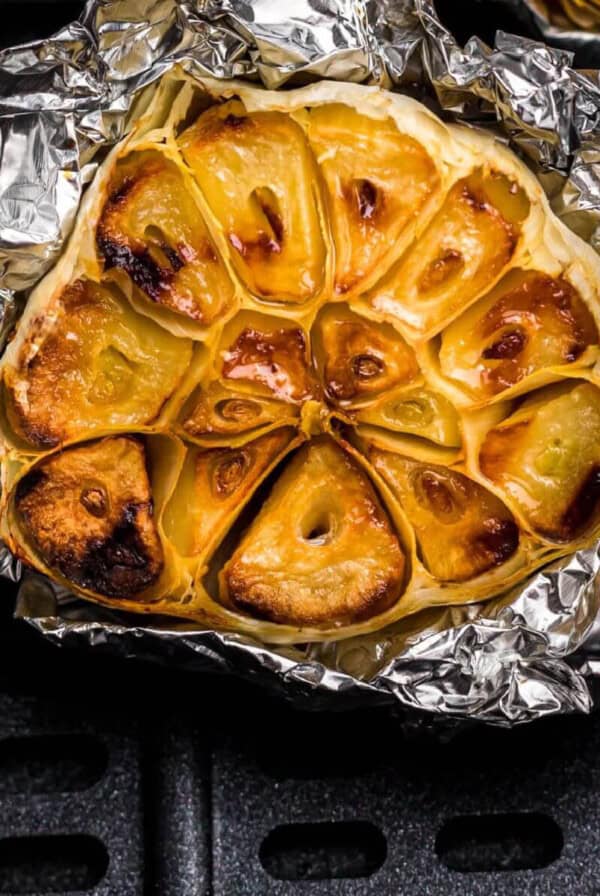 Picture of cooked garlic in foil in air fryer.