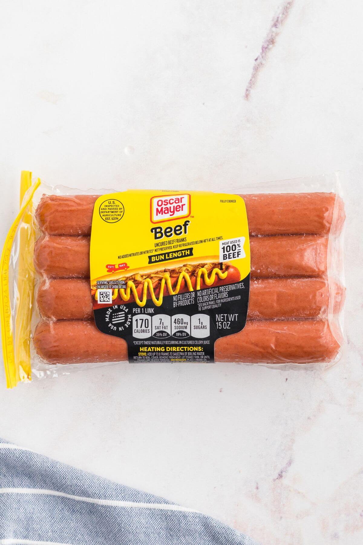 One pack of oscar mayer frozen hot dogs on a marble table. 