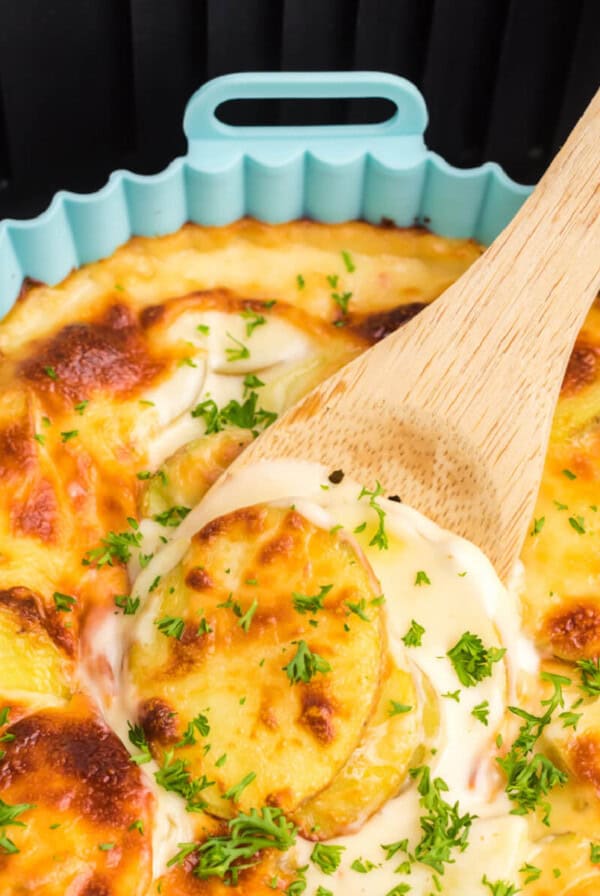 Scalloped potatoes in silicone liner in air fryer basket.