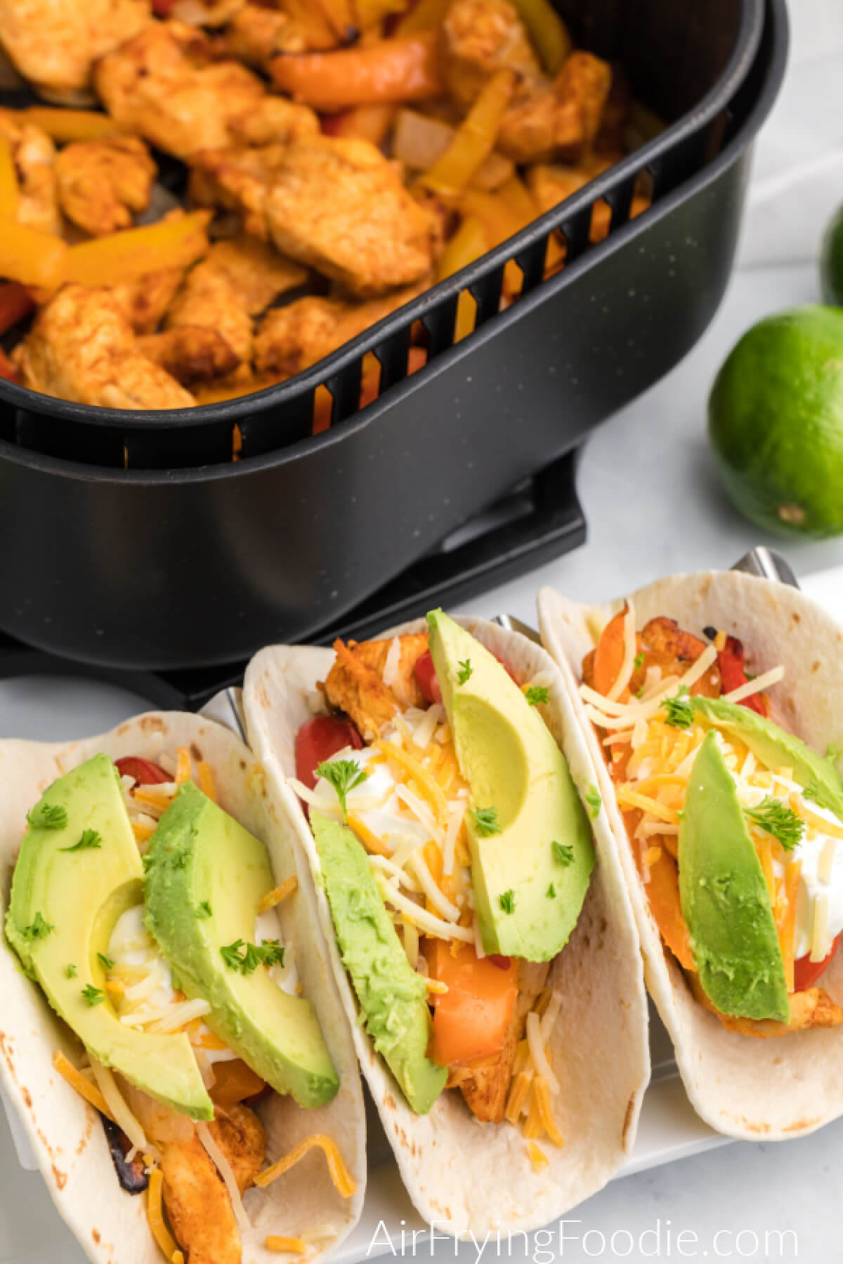 Chicken fajitas served in flour tortillas topped with cheese, avocado slices, and fresh parsley flakes. 