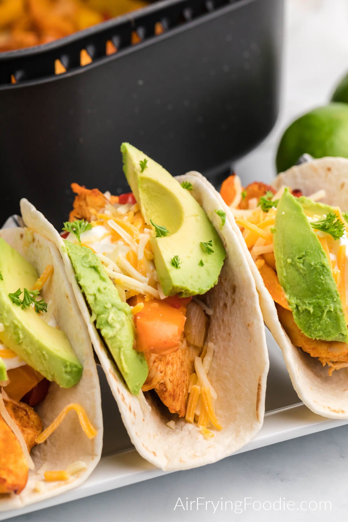 air fried chicken fajitas served on flour tortillas with sliced avocado, cheese, and fresh cilantro. 
