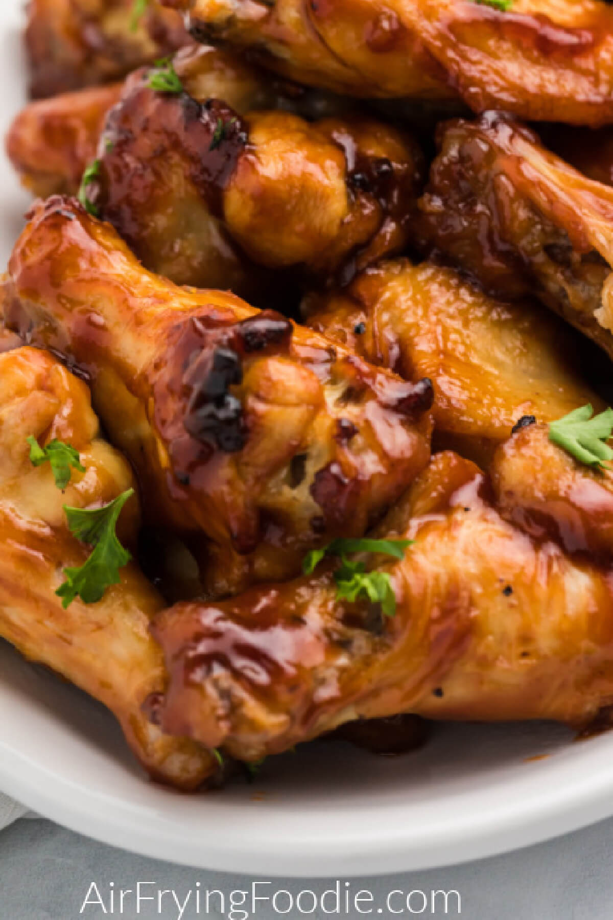 Close up of air fryer bbq chicken wings on a white serving platter. 