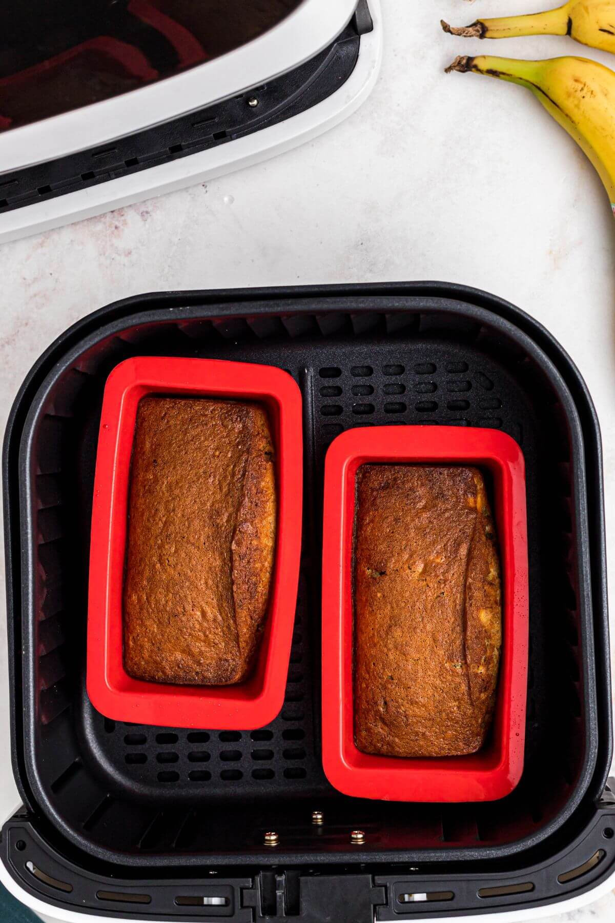 Baked banana bread in red silicone mini loaf pans. 