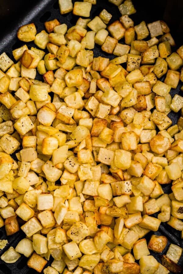 Golden and crispy cooked diced potatoes after being cooked and seasoned in the air fryer.