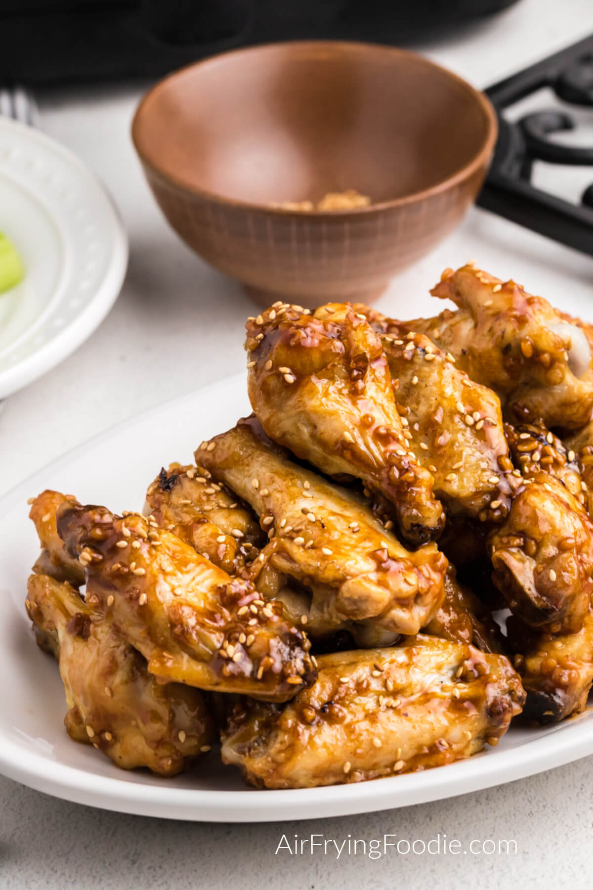 honey garlic chicken wings made in the air fryer and served up on a white plate. 