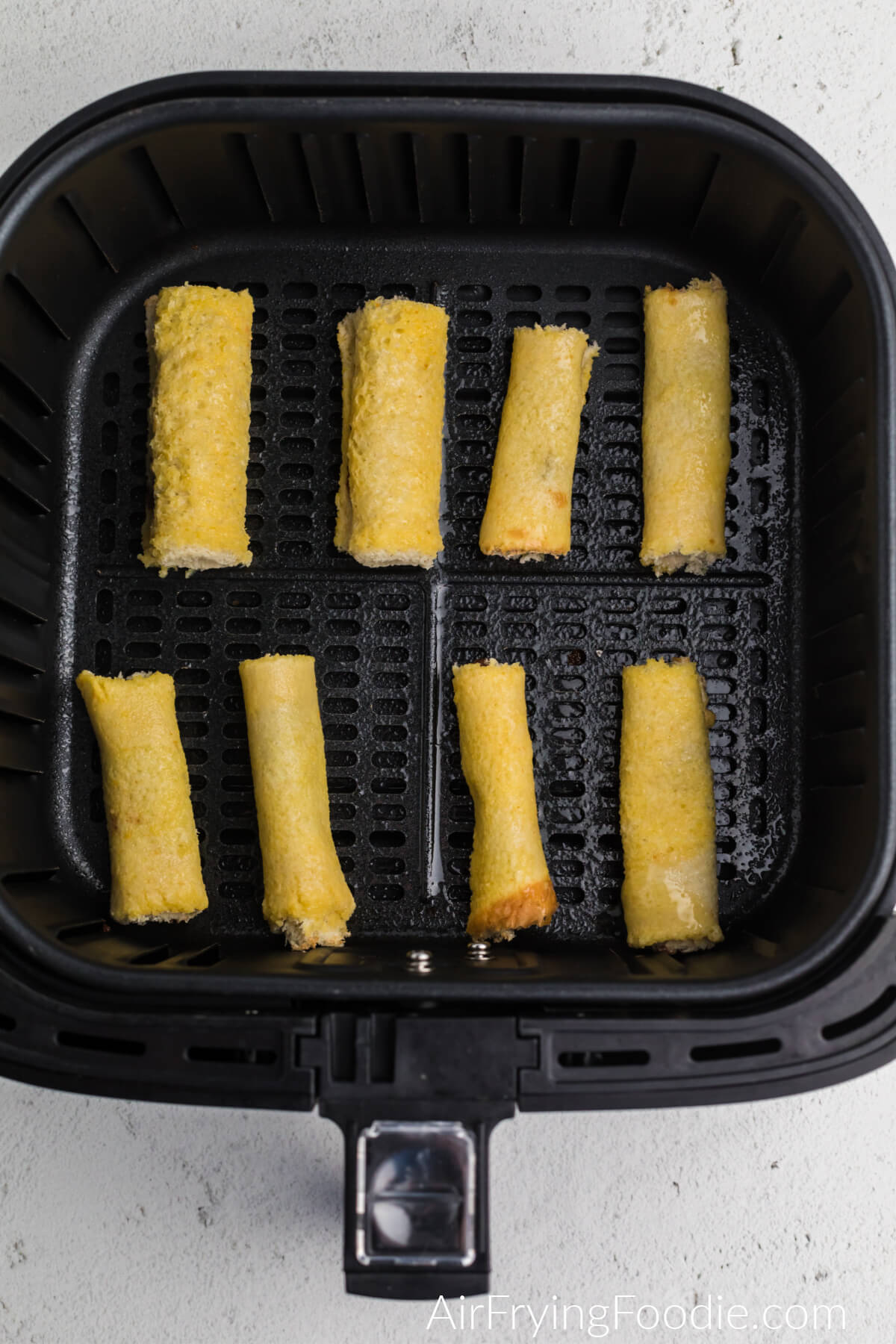 Nutella french toast roll ups in the air fryer basket ready to cook. 
