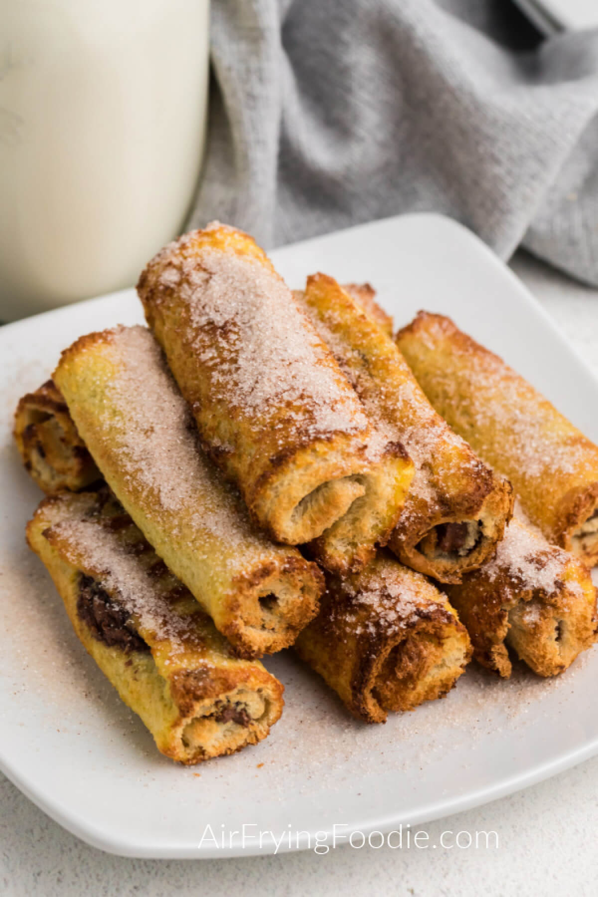 Nutella stuffed french toast roll ups made in the air fryer and served on a plate. 