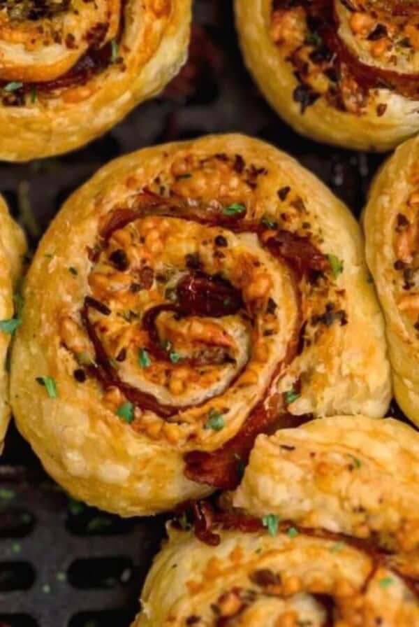 Golden flaky stuffed pinwheels in the air fryer basket.