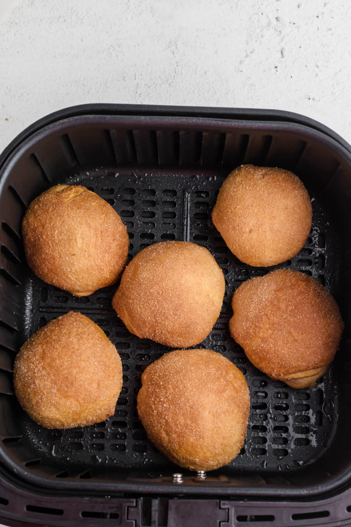golden brown cherry pie bombs in the basket of the air fryer. 
