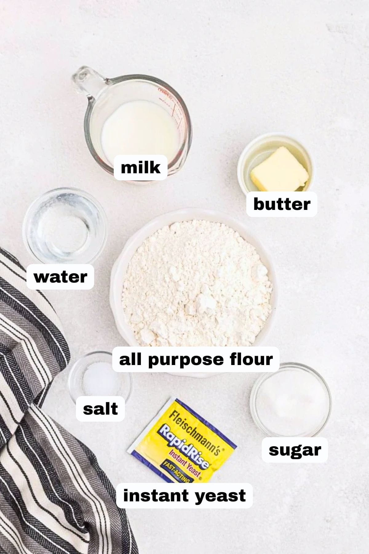 Ingredients needed to make bread in the air fryer in small glass bowls on a marble table.