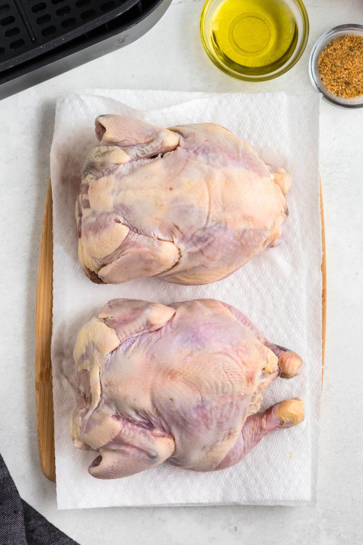 Uncooked Cornish hens on a paper towel before being seasoned. 