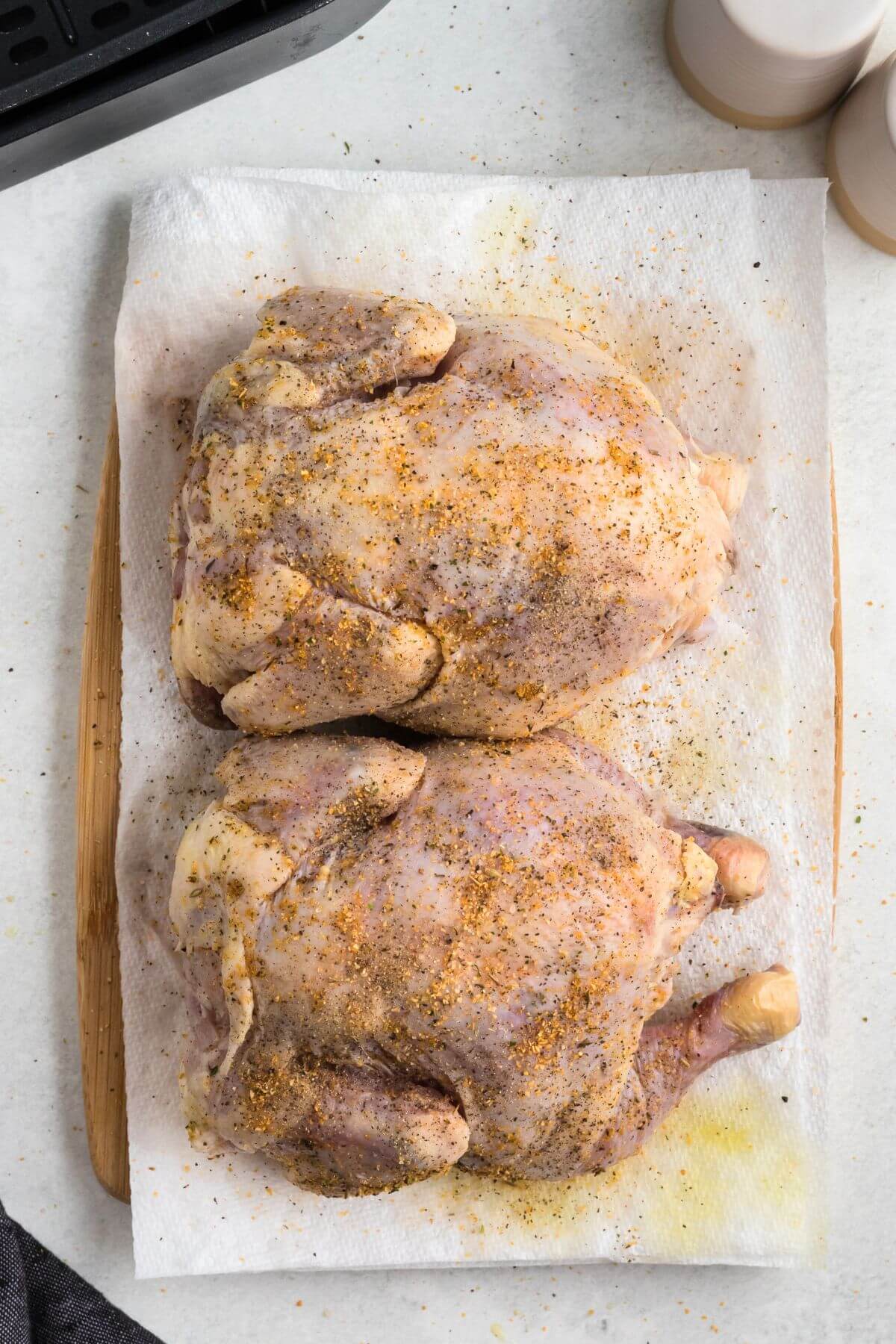 Seasoned Cornish hens on a paper towel before being cooked. 