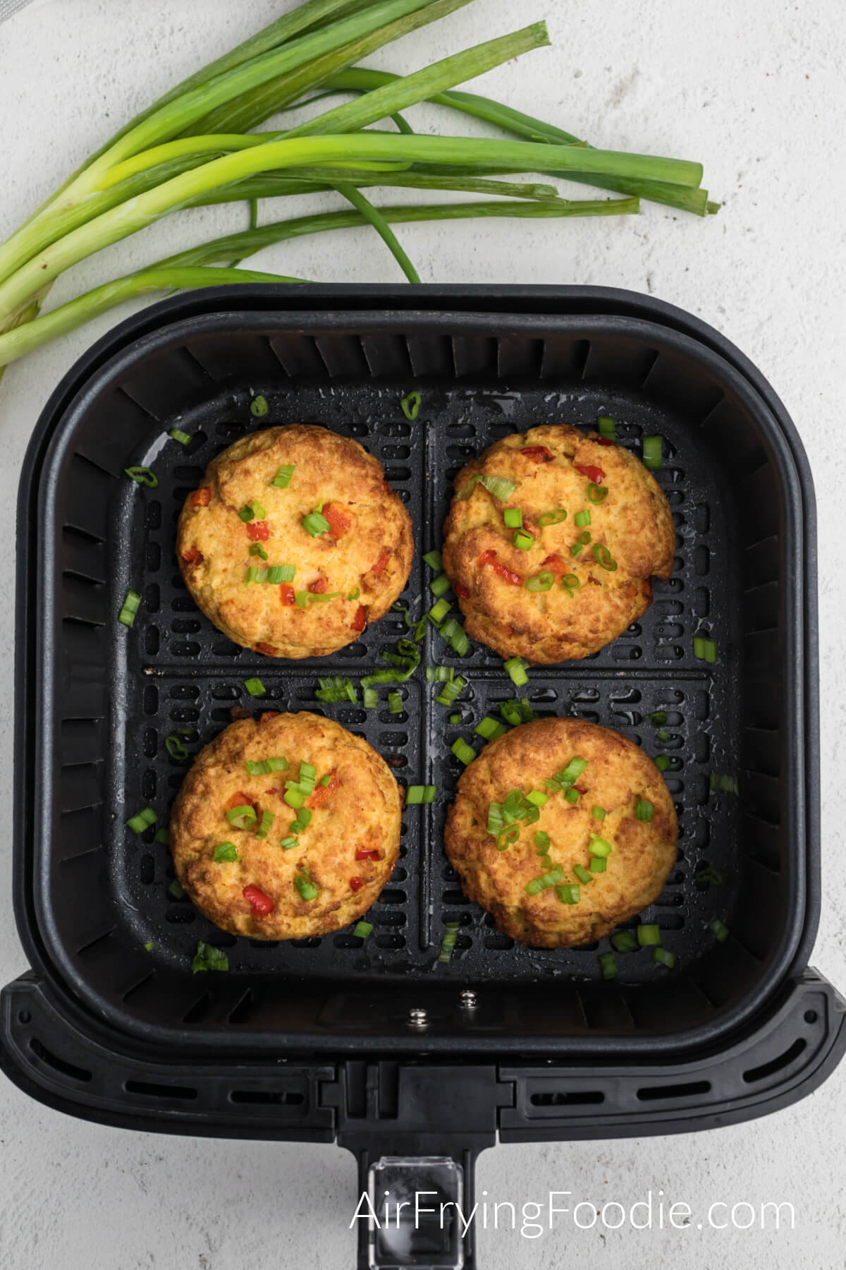 Crab cake patties in the basket of the air fryer. 