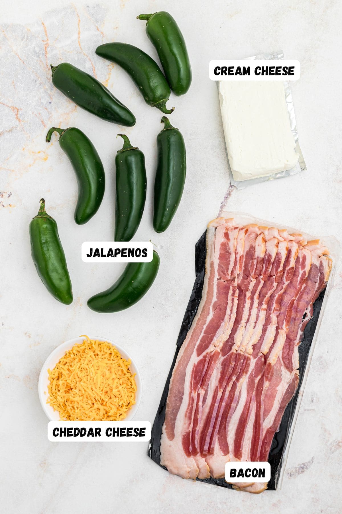 Bacon, cheese, cream cheese, and jalapenos, on a marble table. 