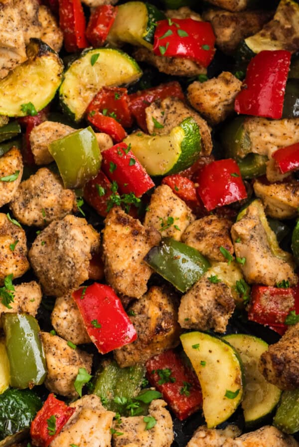 chicken and vegetables in the basket of the air fryer, ready to eat.