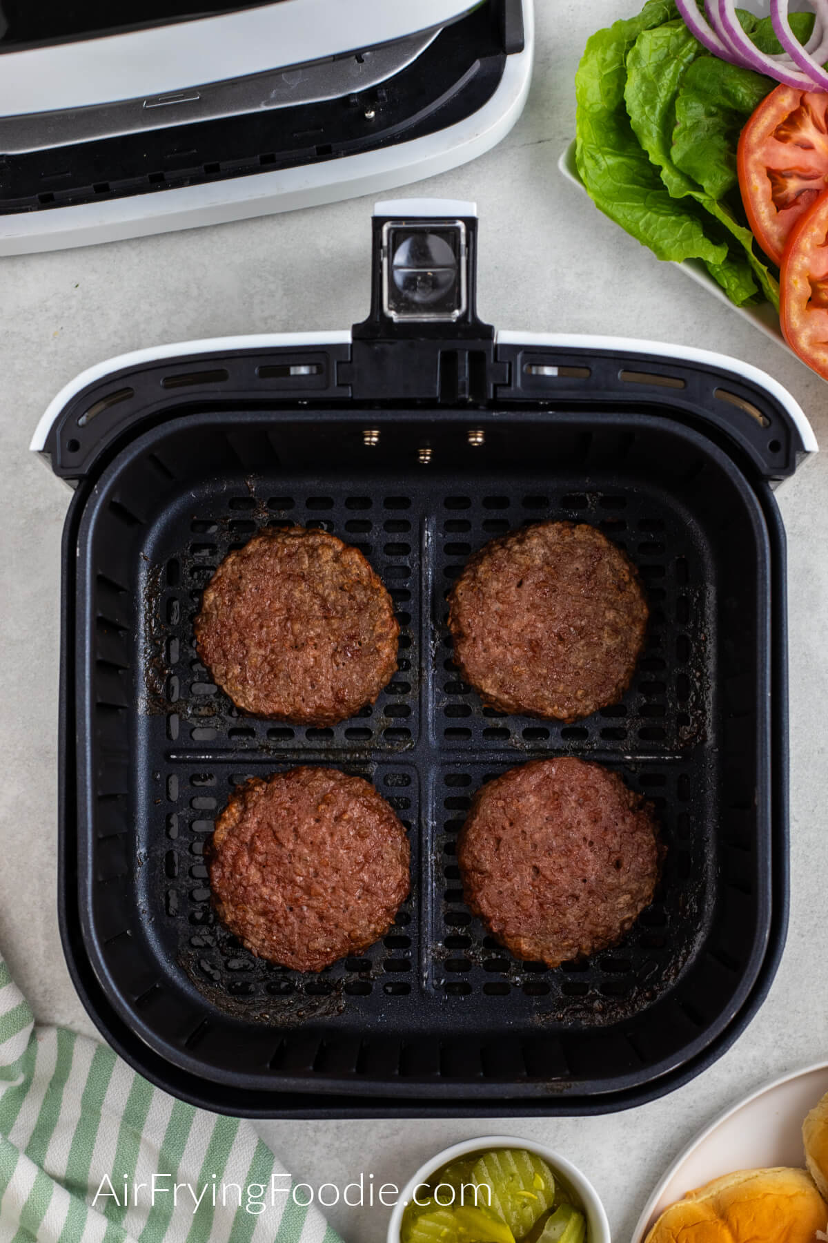 Air fried Beyond burgers in the basket of the air fryer. 