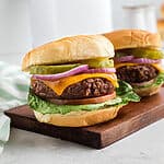 Close up of two air fried Beyond burgers on a cutting board.