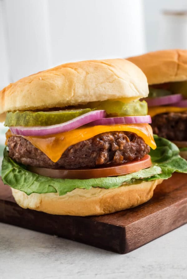 Close up of two air fried Beyond burgers on a cutting board.