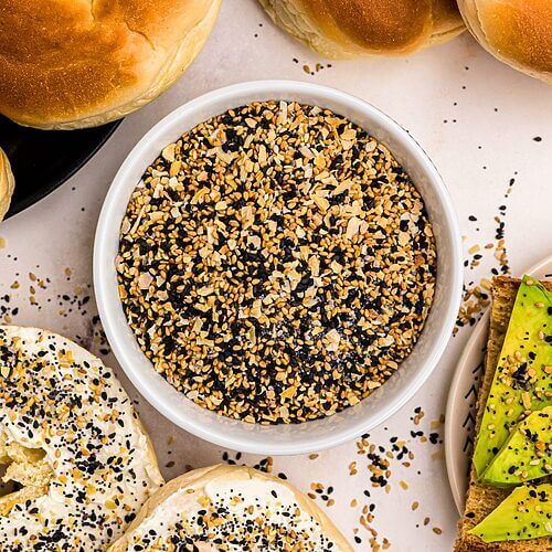 Everything Bagel Seasoning in a small bowl surrounded by bagels and avocado toast.