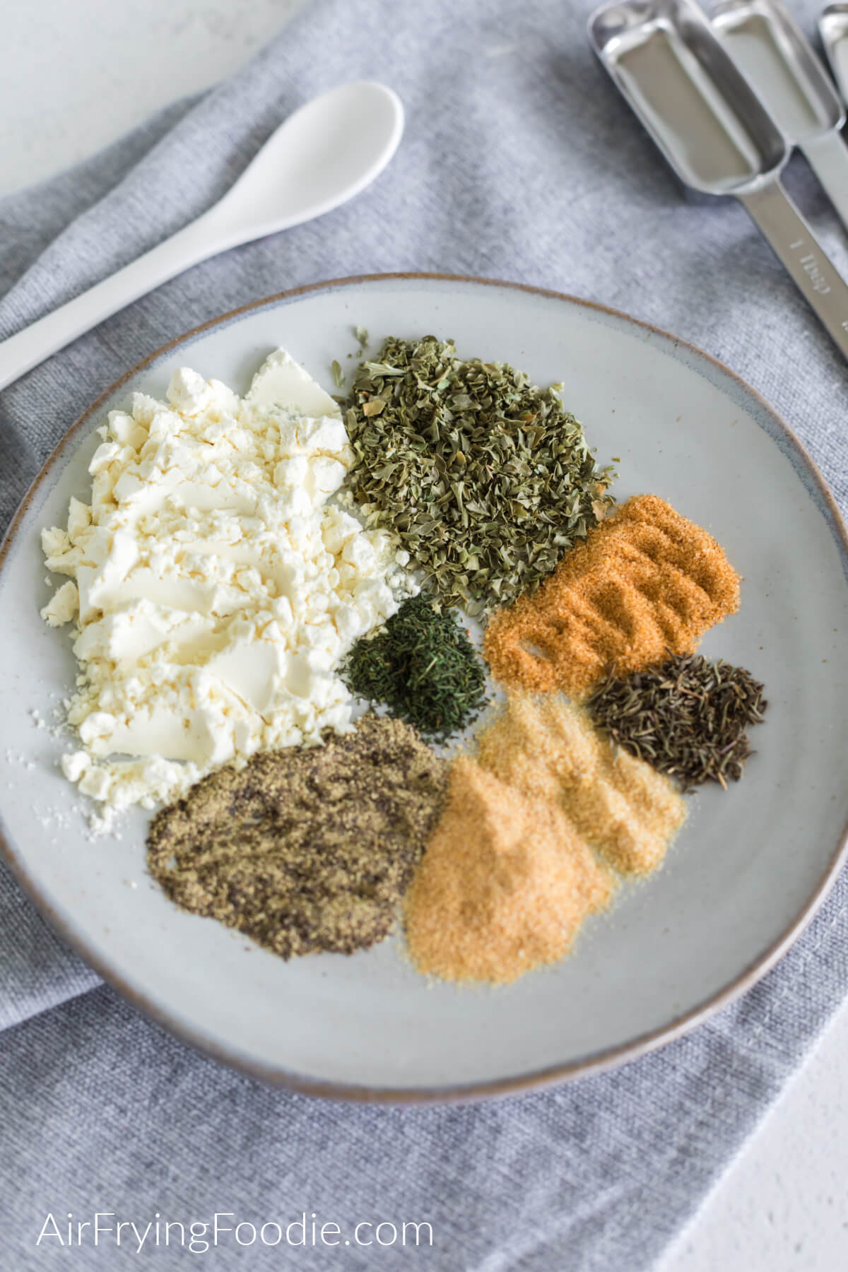 Ingredients needed to make Homemade Ranch seasoning measured out into portions before mixing together and blending into the seasoning. 
