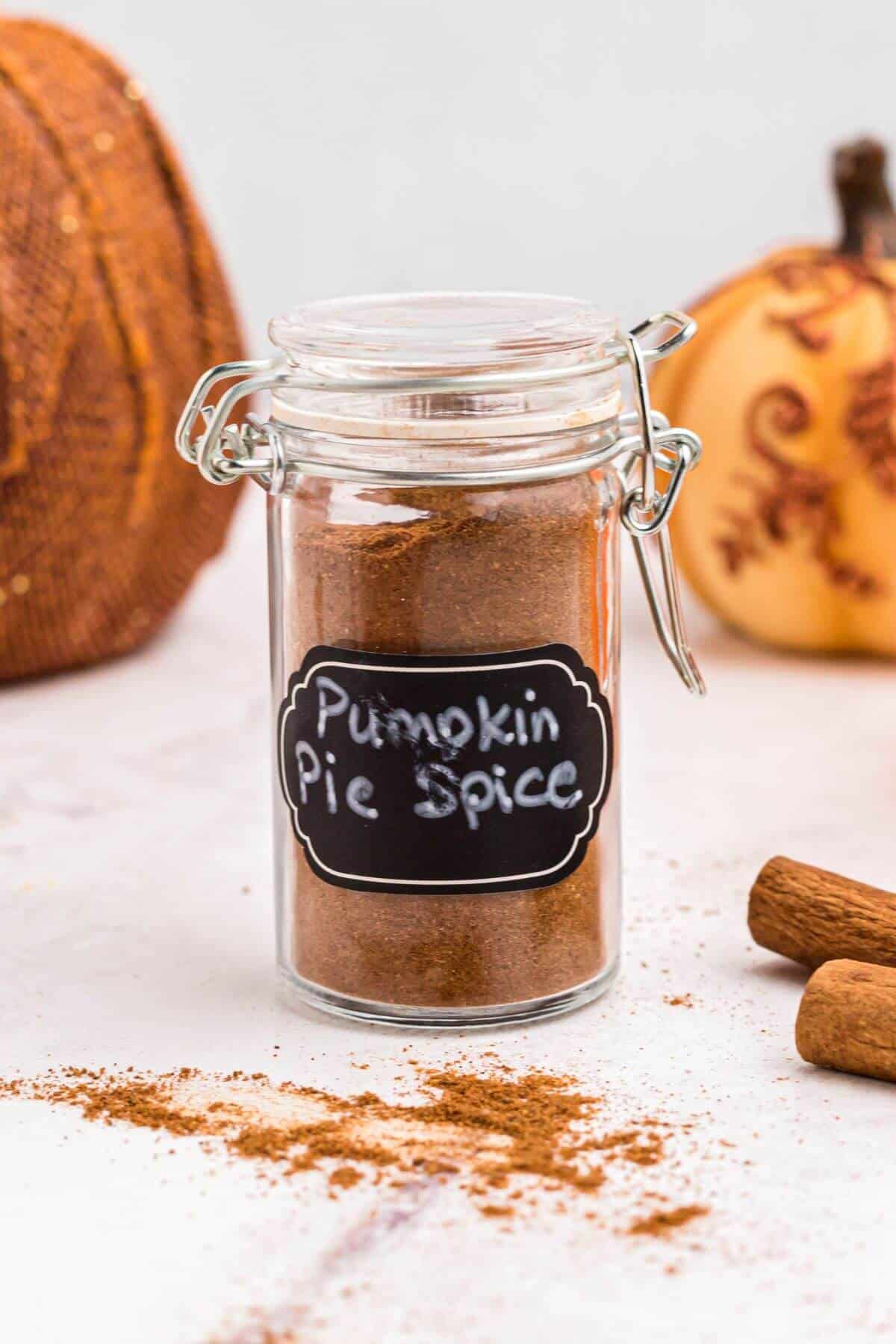 Pumpkin spice in a small spice jar on a marble table. 