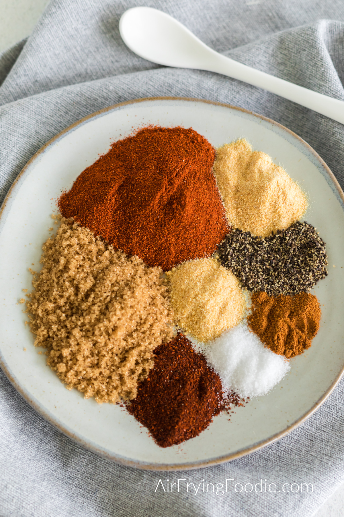 Seasonings measured out on a plate to combine to make a homemade bbq rub. 