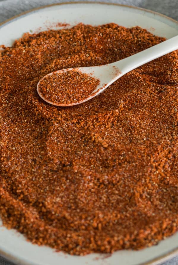 Homemade BBQ rub recipe to use on meats and vegetables, on a white plate.