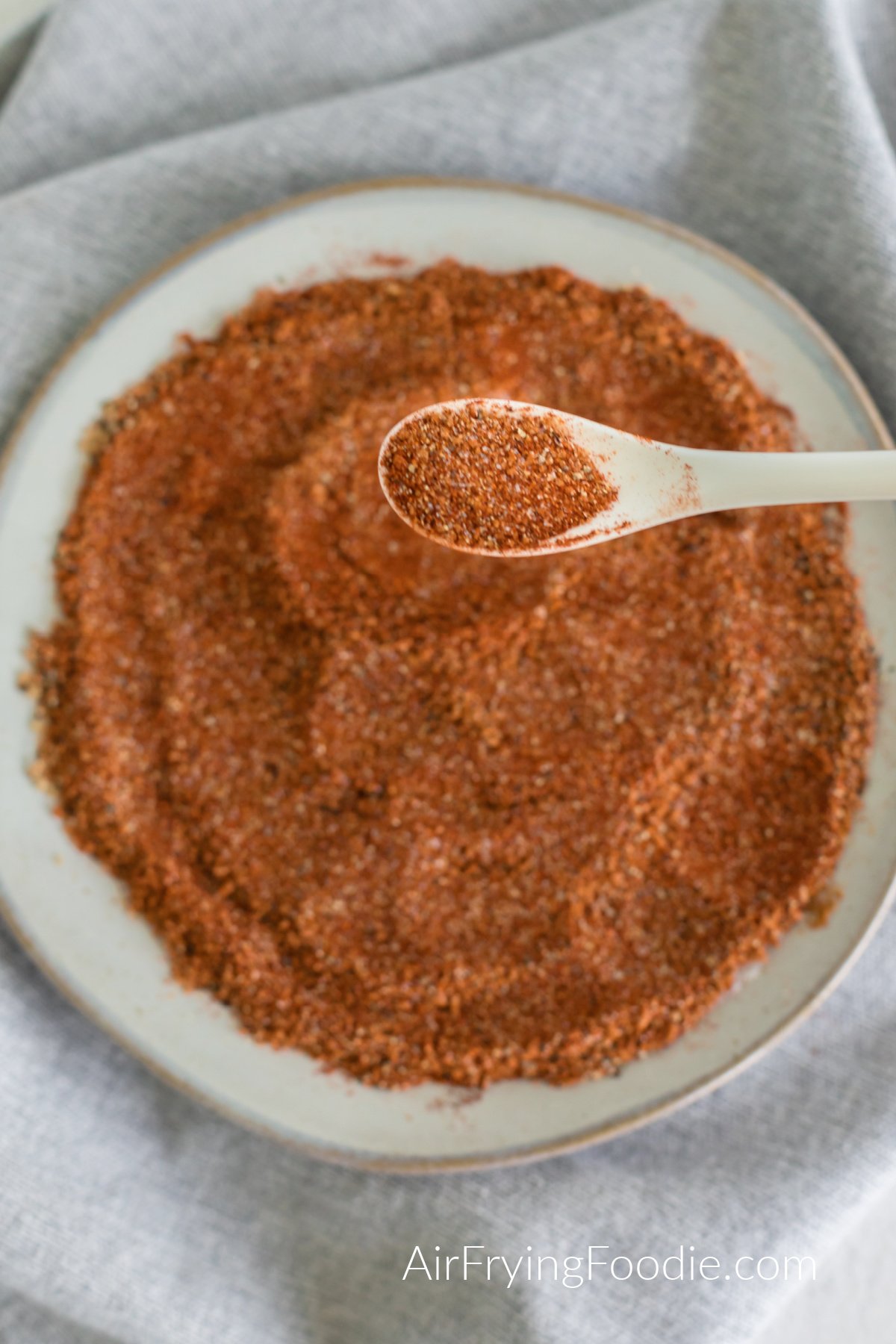 Homemade BBQ seasoning with a spoonful of homemade seasoning. 