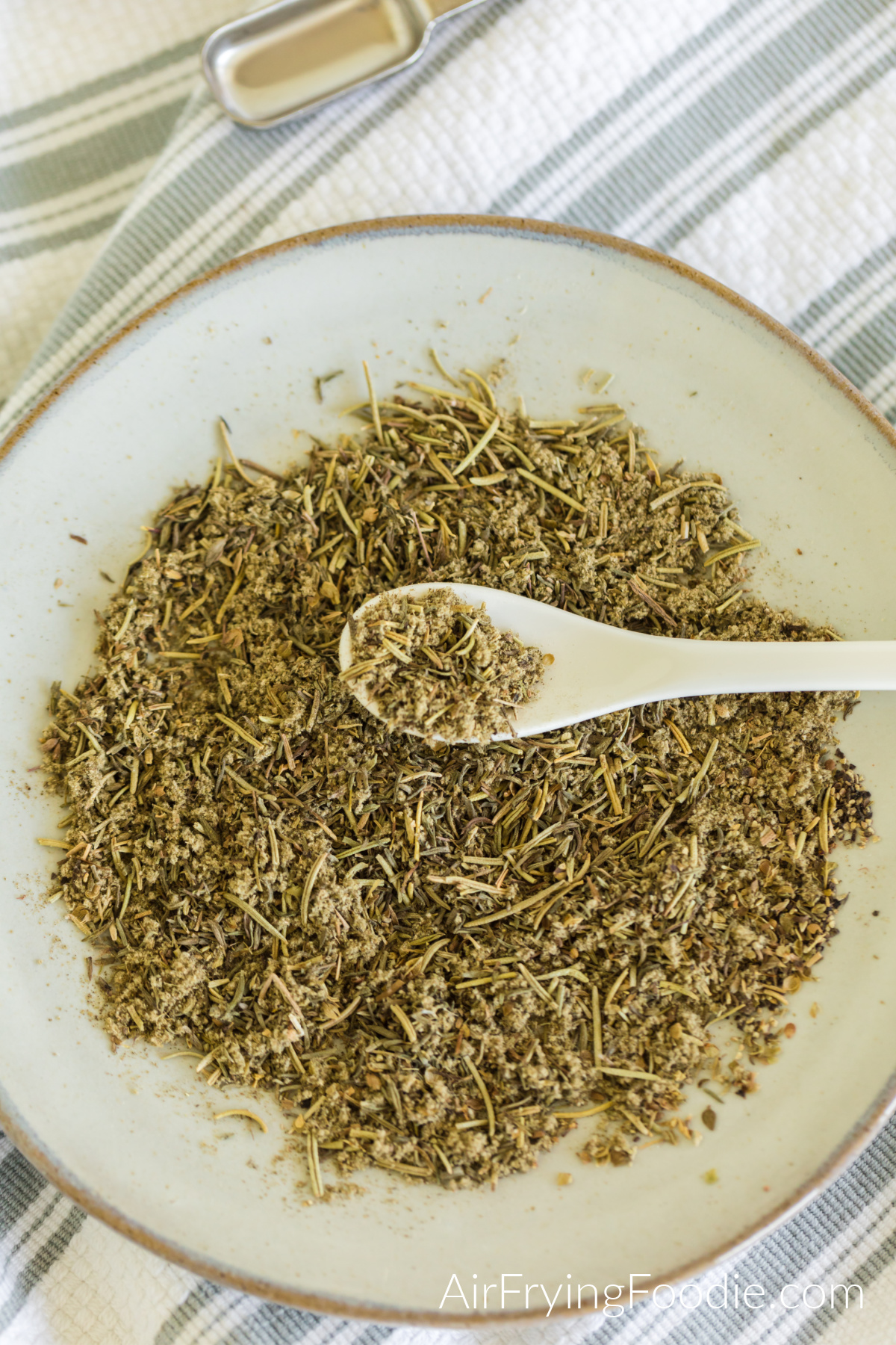 Homemade poultry seasoning in a dish with a spoon ready to use. 