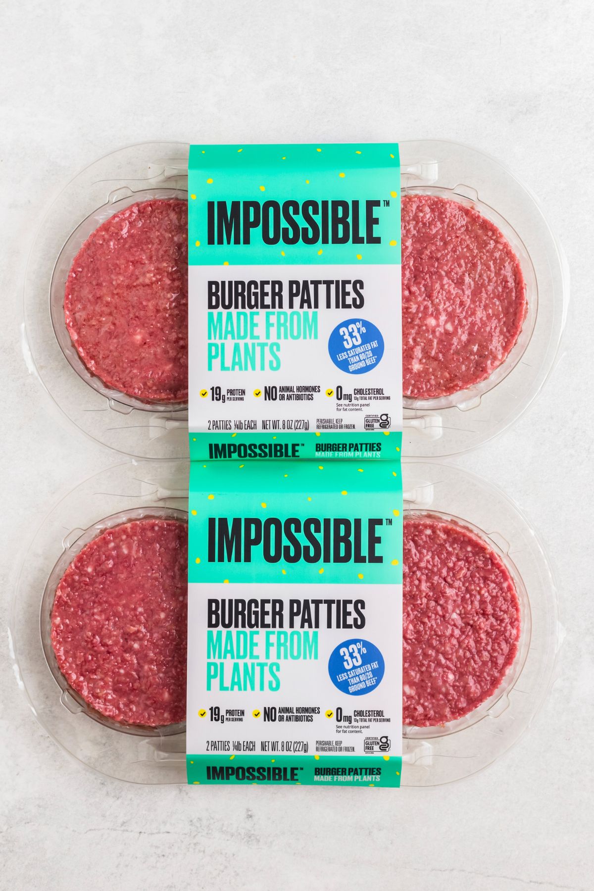 Impossible burger patties in their packaging on a marble table. 