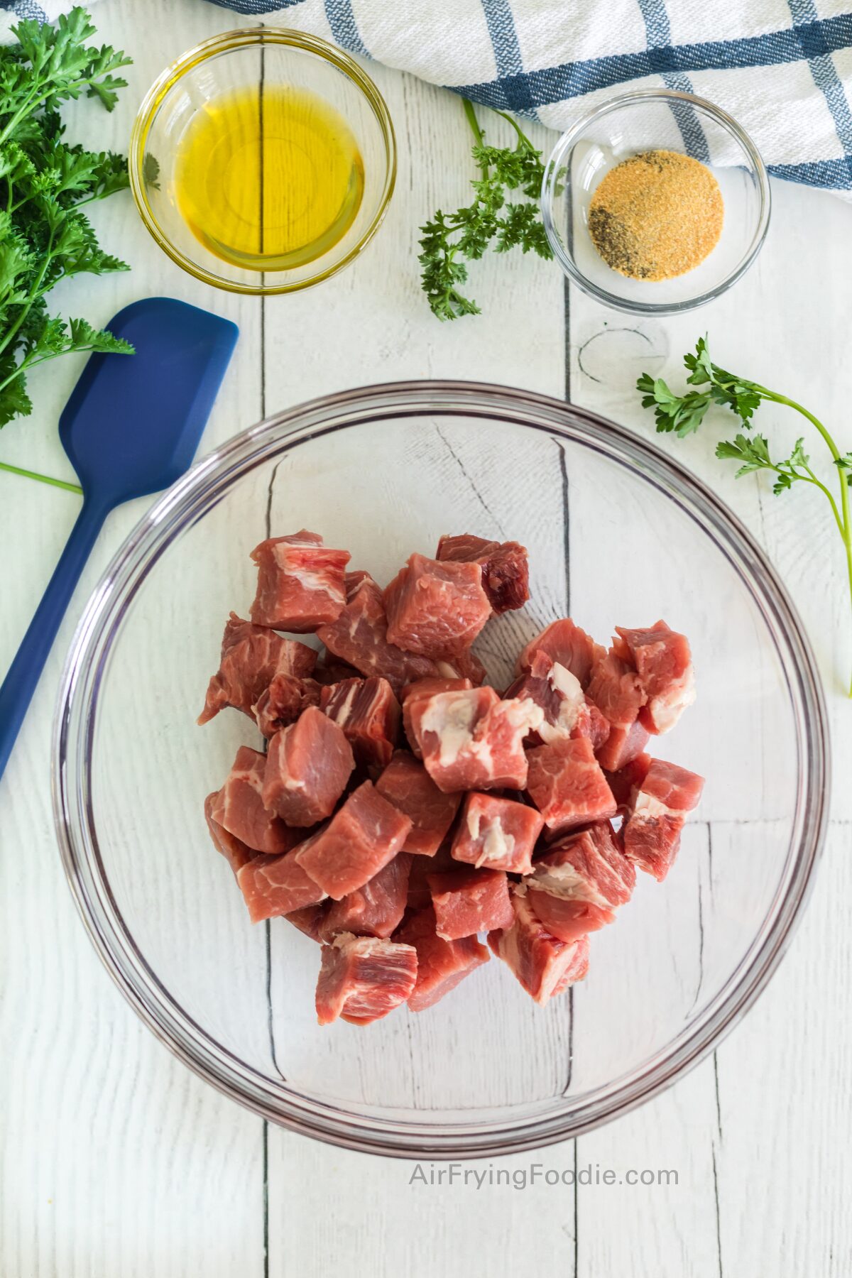 Steaks cut into bite sized pieces and placed into a mixing bowl. 