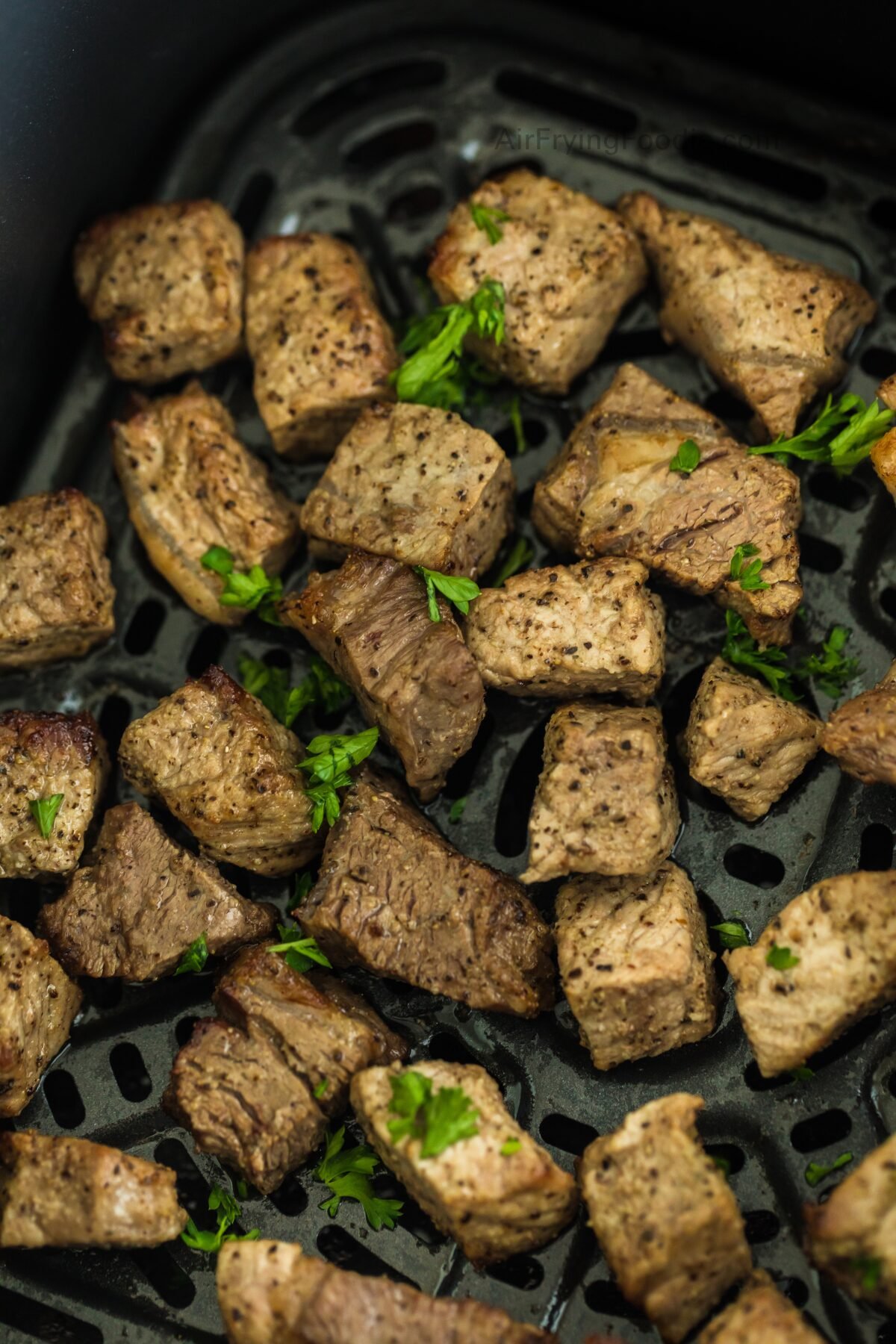 Garlic steak bites in the air fryer basket. 