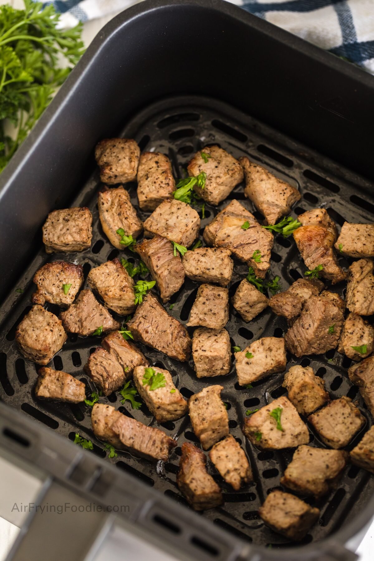 Steak bites in air fryer basket ready to serve. 