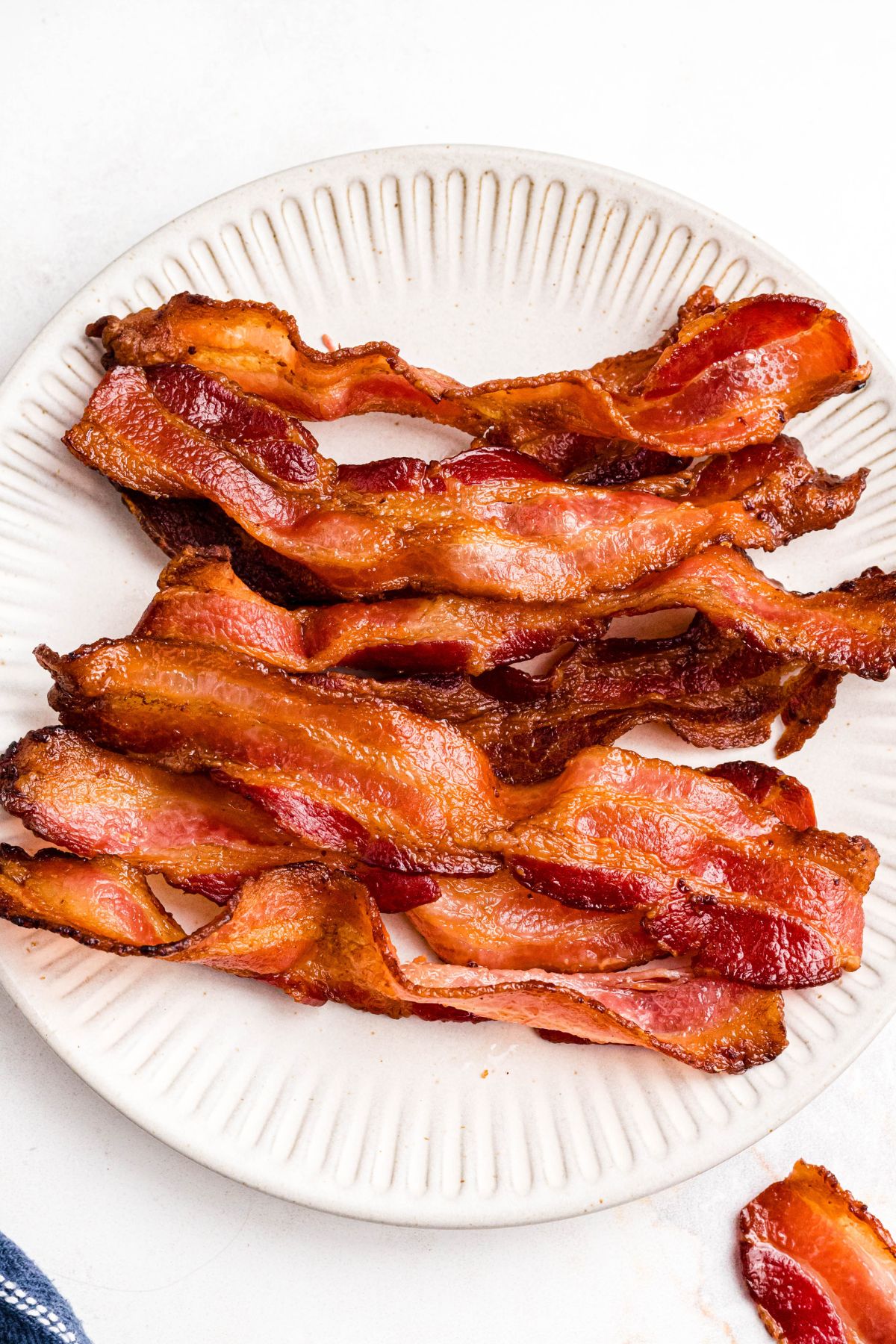 Golden crispy bacon on a cream plate. 